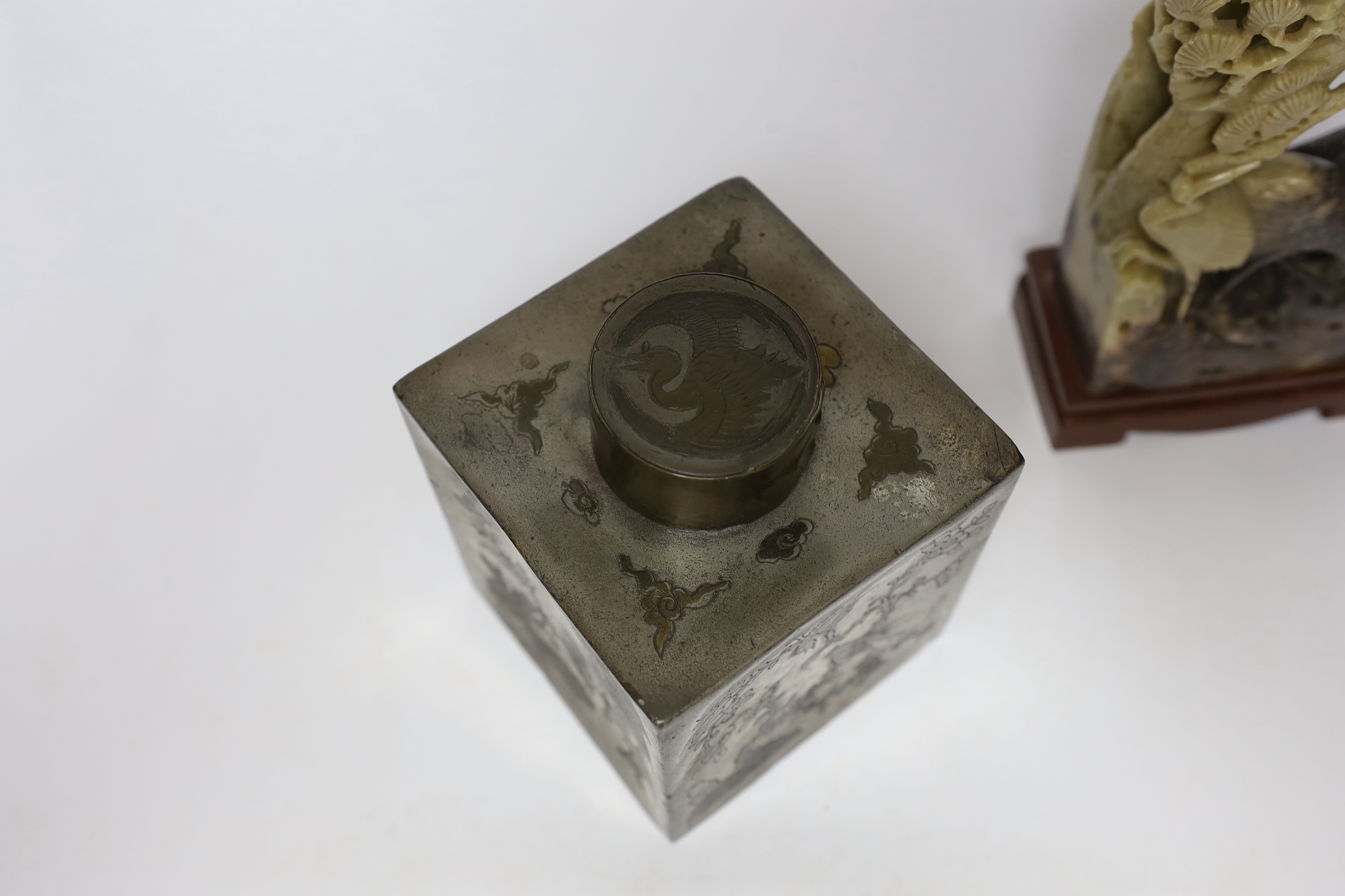 Two Chinese soapstone carvings and a pewter tea canister decorated with birds, largest 24cm high